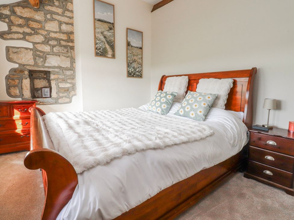 A bedroom with a bed, pillows, and a lamp at Vasey Croft Stanbury near Haworth