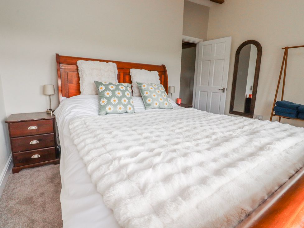 A bedroom with a bed and nightstand at Vasey Croft in Stanbury near Haworth