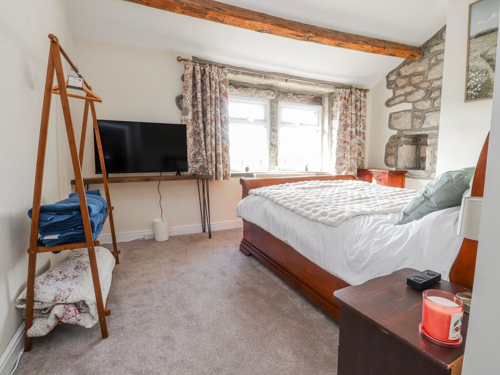 A bedroom with a bed and television at Vasey Croft in Stanbury near Haworth