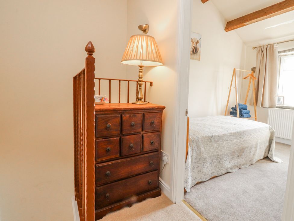A bedroom with a chest of drawers and a bed at Vasey Croft in Stanbury near Haworth