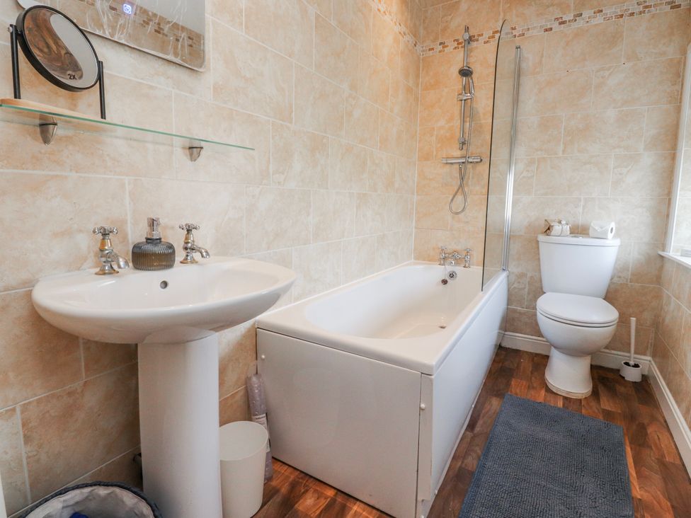 A bathroom with a sink, bathtub, and toilet at Vasey Croft in Stanbury near Haworth
