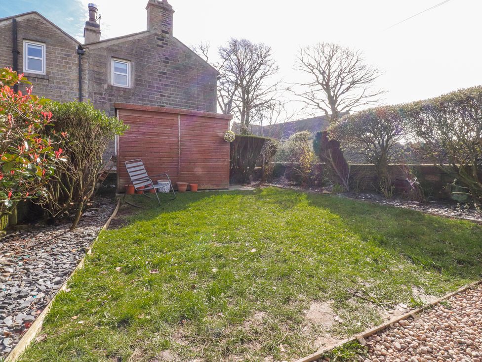 A garden with a grass area and a shed at Vasey Croft Stanbury near Haworth
