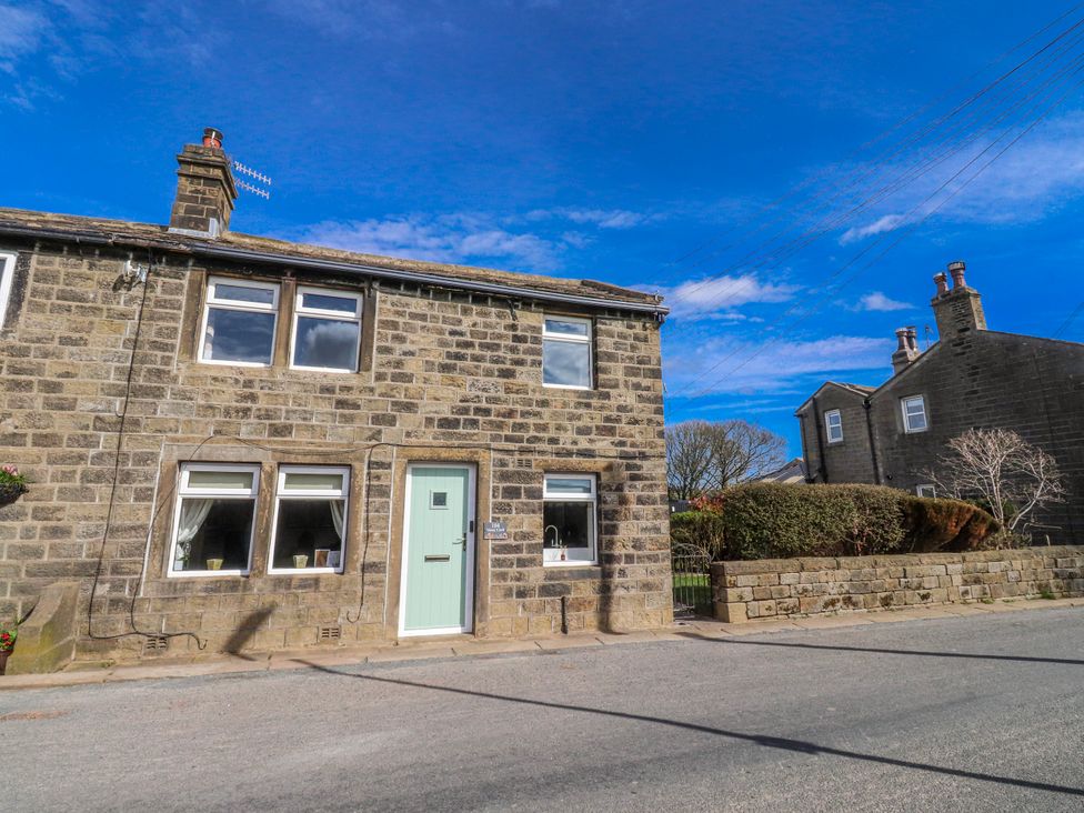 A house with a green door and multiple windows at Vasey Croft in Stanbury near Haworth