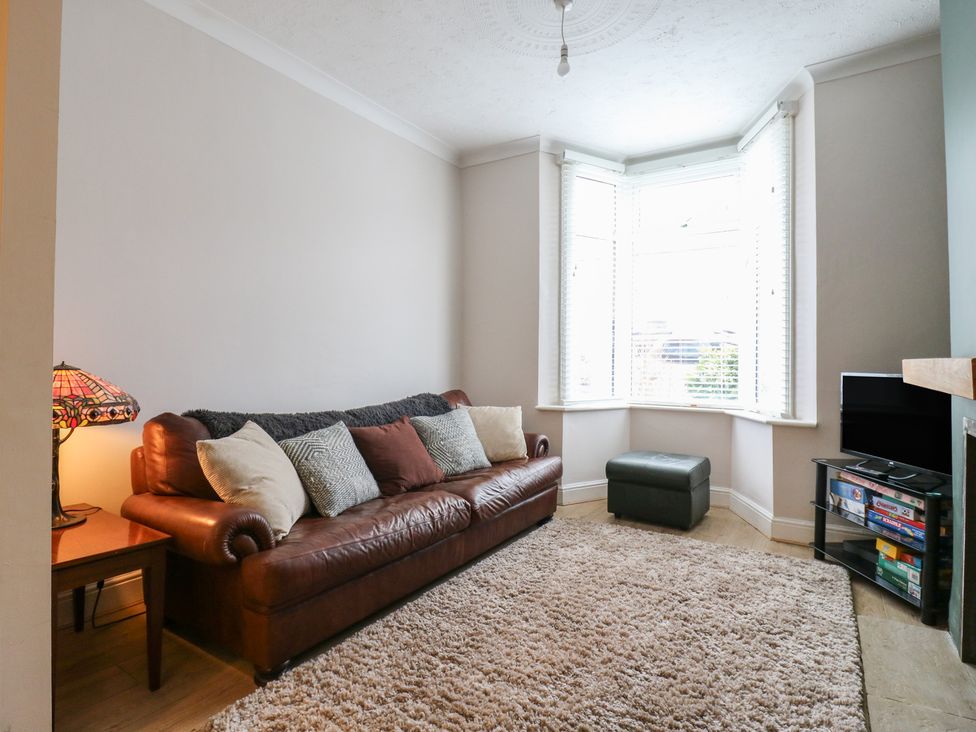 A living room with a sofa and television at Meregate Cottage in Margate