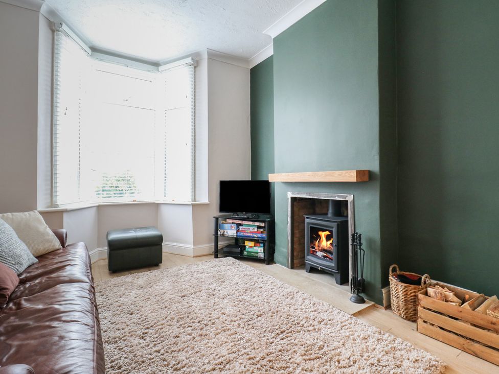 A living room with a fireplace and sofa at Meregate Cottage in Margate