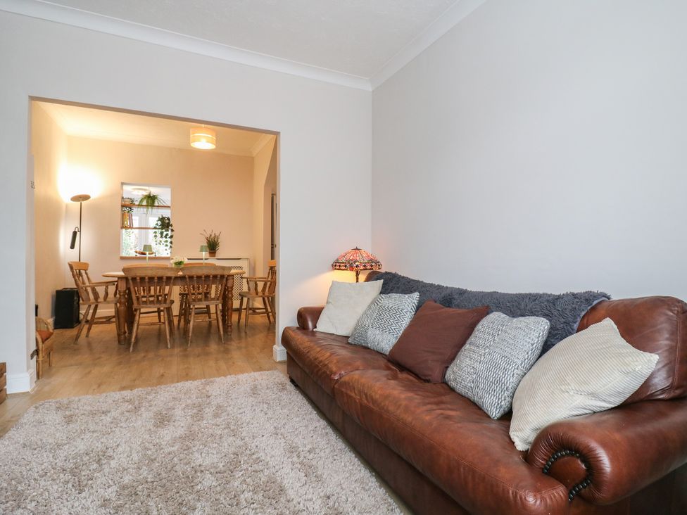 A living room with a sofa and a dining area at Meregate Cottage in Margate