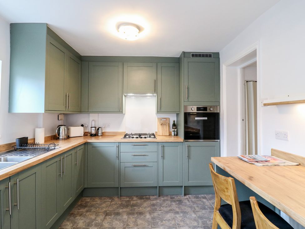 A kitchen with cabinets and cooking appliances at Meregate Cottage in Margate