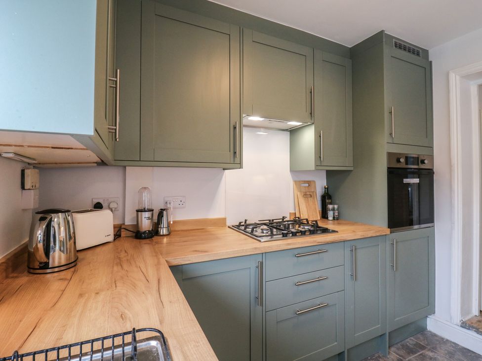 A kitchen with cabinets and appliances at Meregate Cottage in Margate
