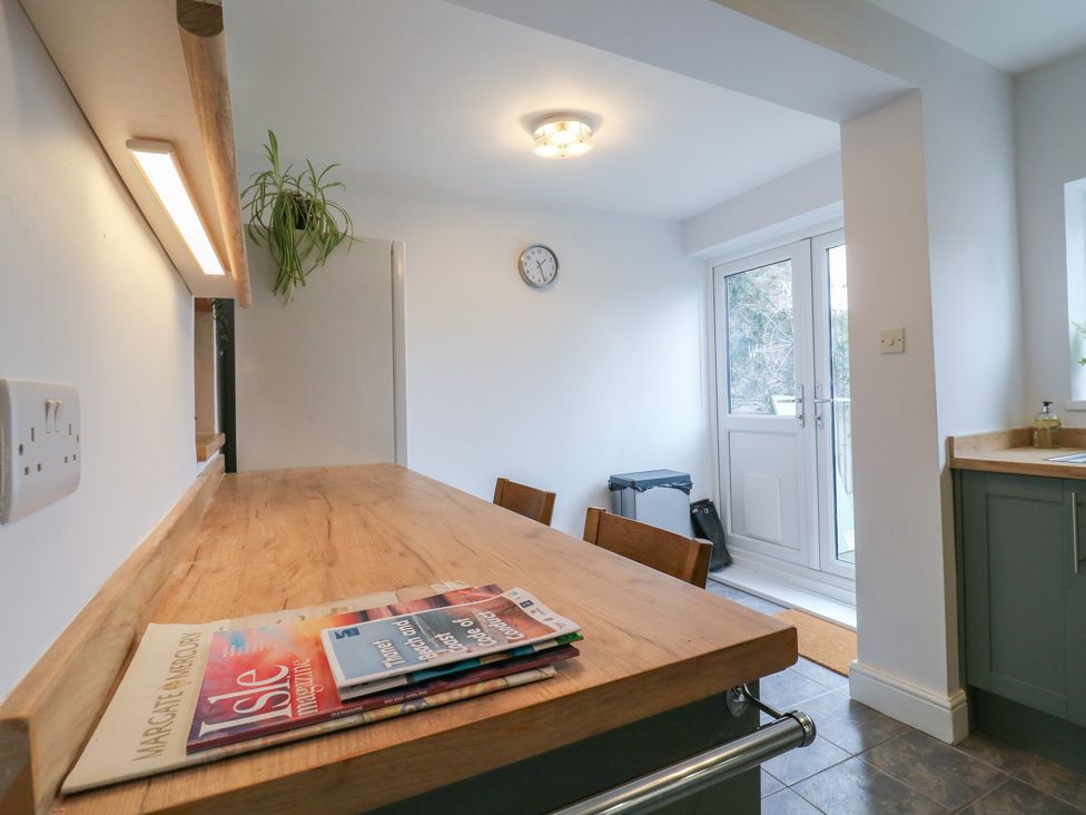 A kitchen with a wooden table and chairs at Meregate Cottage in Margate