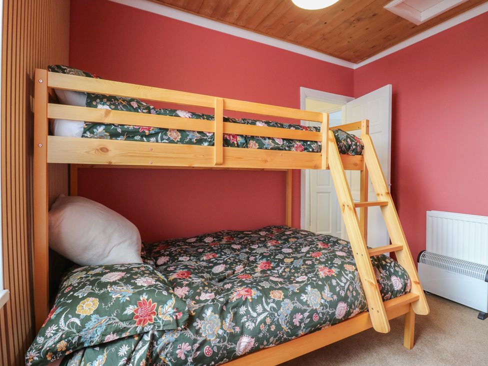 A bunk bed with floral bedding in a bedroom at Meregate Cottage in Margate