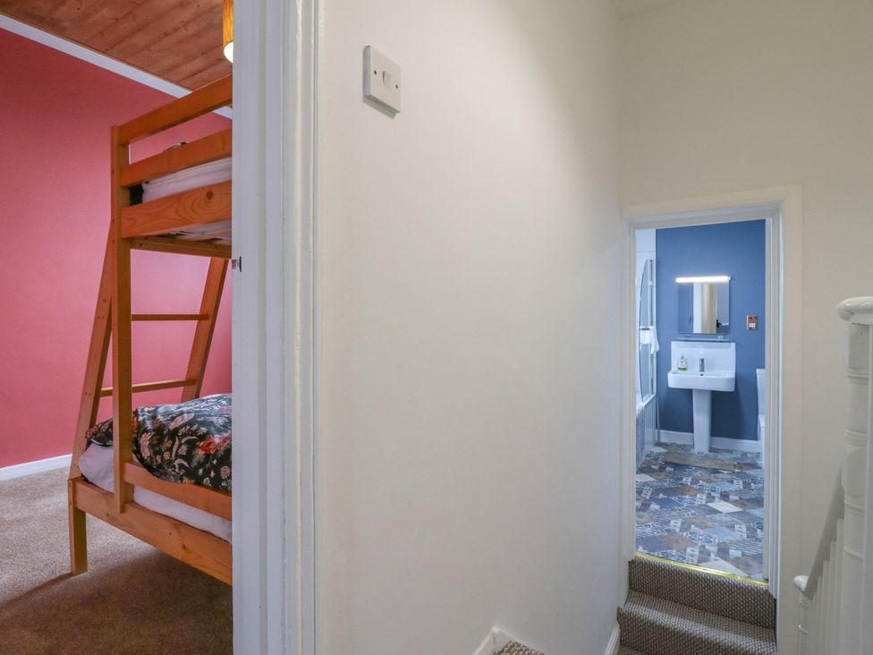 A bedroom with a bunk bed and an adjacent bathroom at Meregate Cottage in Margate