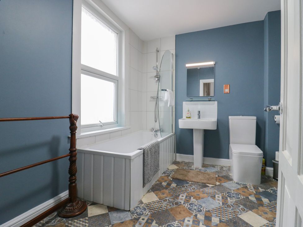 A bathroom with a bathtub, toilet, and washbasin at Meregate Cottage in Margate