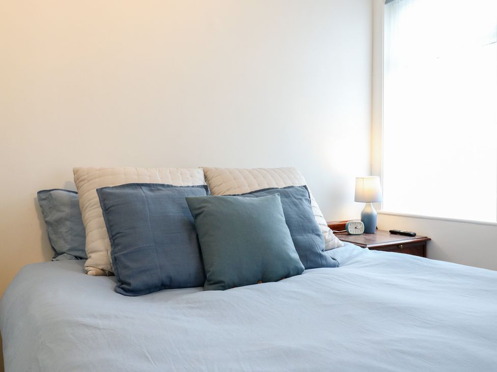 A bedroom with a bed and lamp at Meregate Cottage in Margate