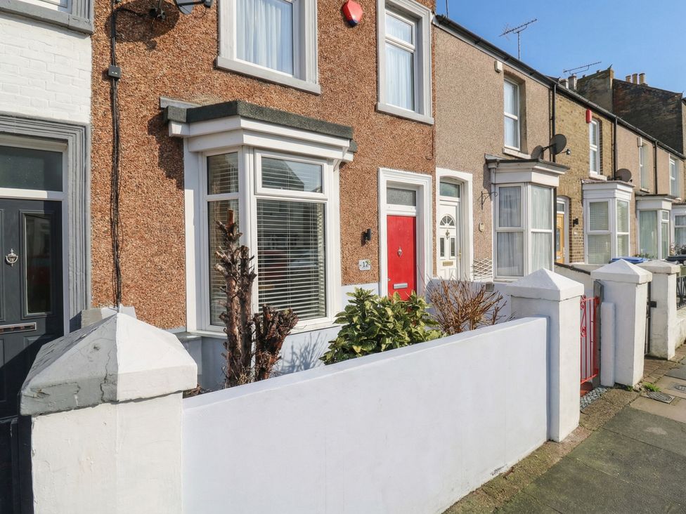 A house exterior with a red door and plants at Meregate Cottage in Margate