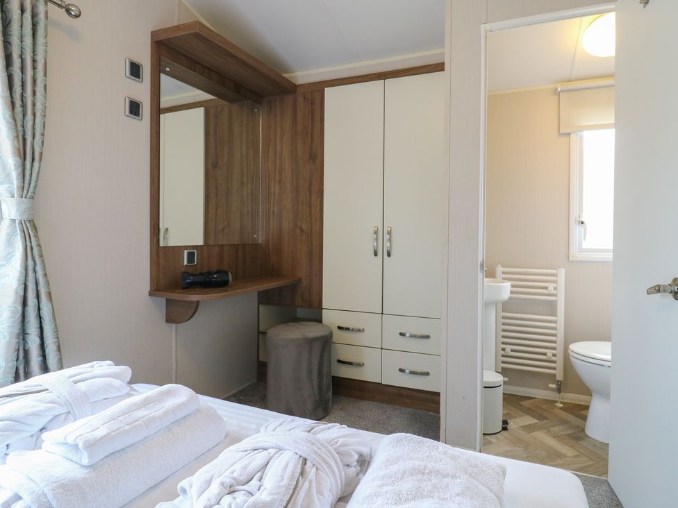 A bedroom with a vanity unit and an adjoining bathroom at MP61 MP Billing Aquadrome Holiday Park Northampton