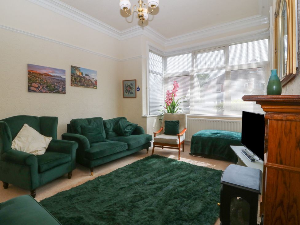 A living room with a sofa and armchair at Gwynfa in Old Colwyn