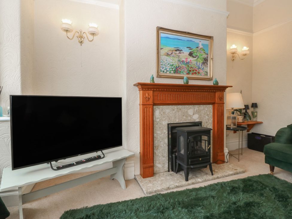 A living room with a television and fireplace at Gwynfa Old Colwyn