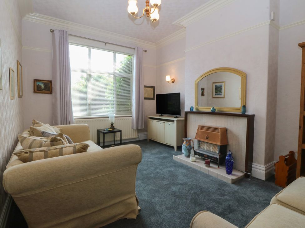 A living room with a TV and a fireplace at Gwynfa in Old Colwyn