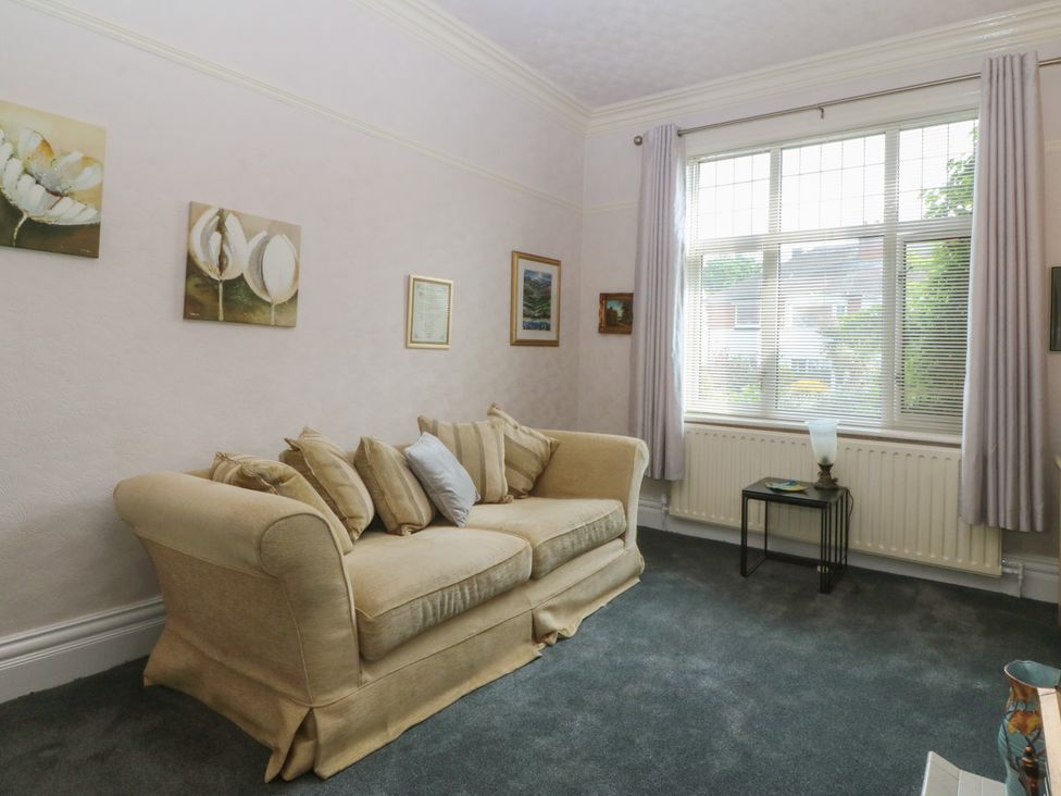 A living room with a sofa and artwork on the walls at Gwynfa in Old Colwyn