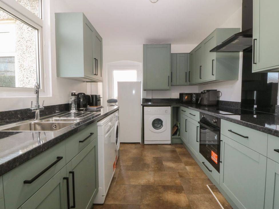 A kitchen with cabinets and appliances at Gwynfa in Old Colwyn