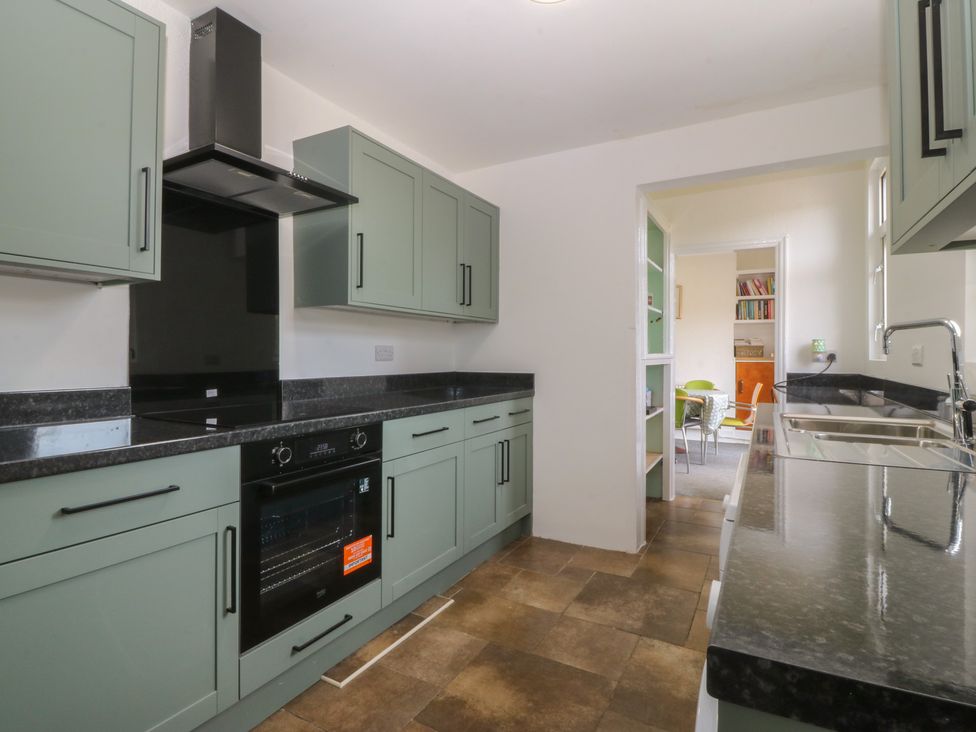 A kitchen with cabinets, oven, and sink at Gwynfa in Old Colwyn