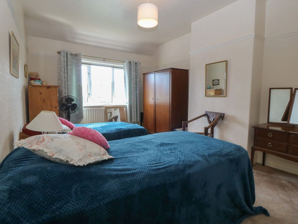 A bedroom with two beds and a wardrobe at Gwynfa in Old Colwyn