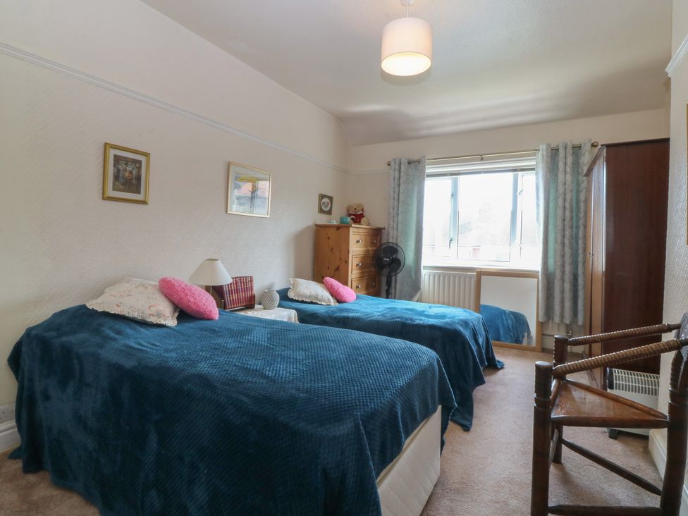 A bedroom with two beds and a dresser at Gwynfa Old Colwyn