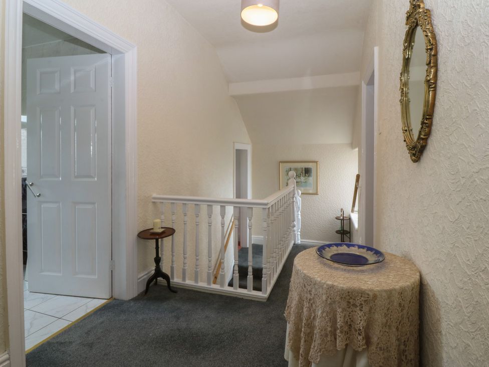 A hallway with a staircase and table at Gwynfa in Old Colwyn