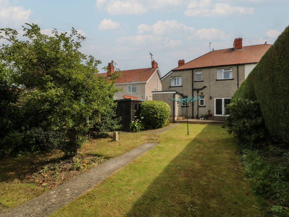 A garden with a washing line and houses at Gwynfa in Old Colwyn