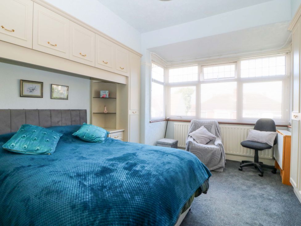 A bedroom with a bed and a chair at Gwynfa in Old Colwyn