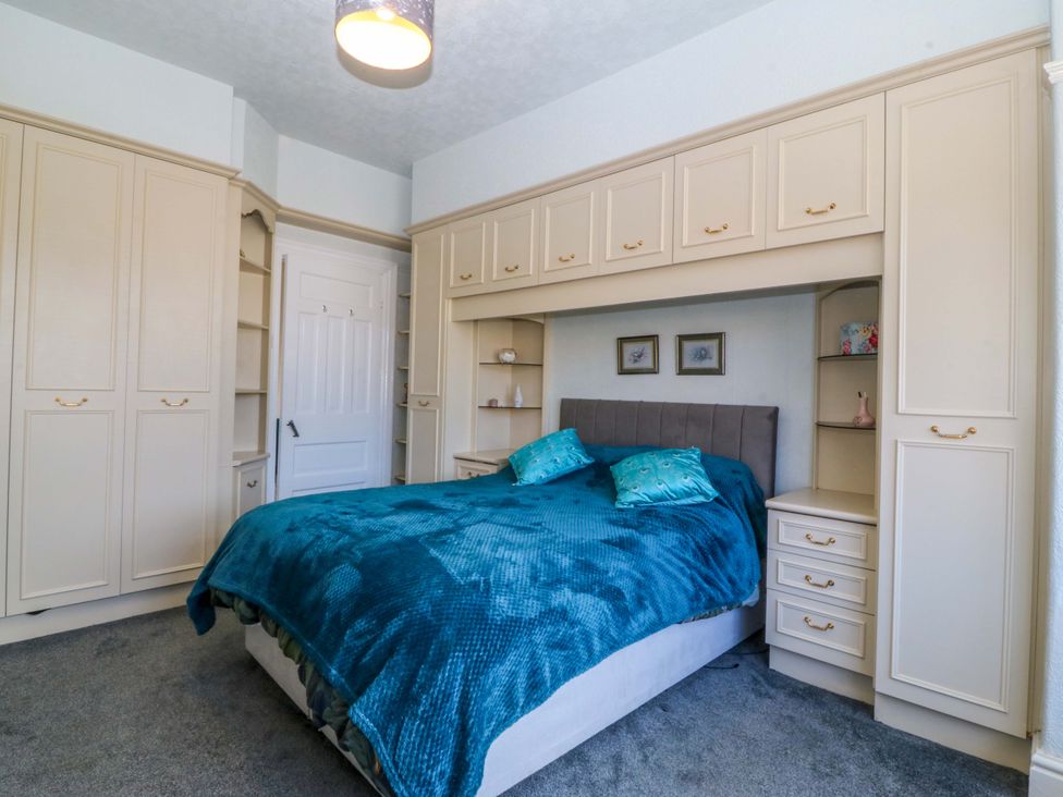 A bedroom with a bed and wardrobe at Gwynfa in Old Colwyn