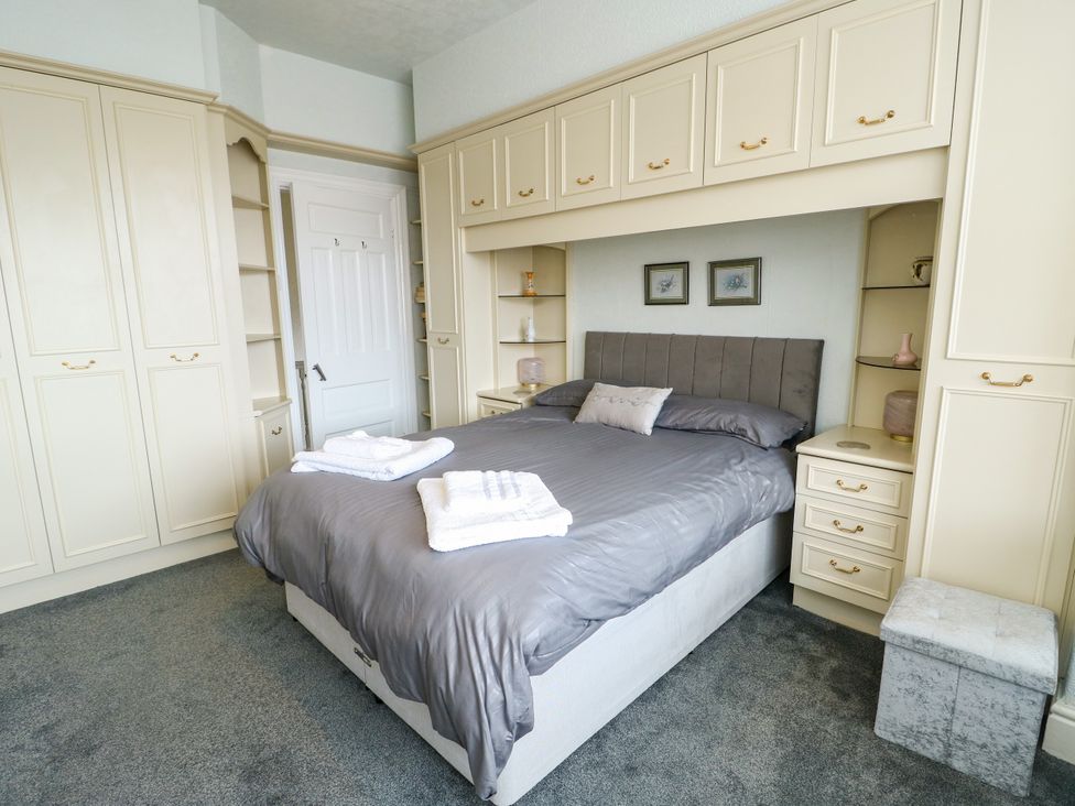 A bedroom with a bed and wardrobe at Gwynfa in Old Colwyn