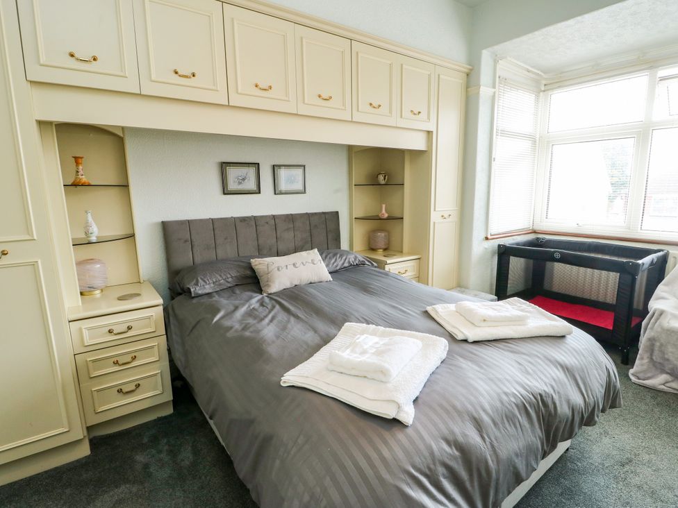 A bedroom with a bed and shelving units at Gwynfa in Old Colwyn