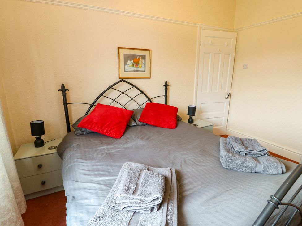 A bedroom with a bed and towels at Gwynfa in Old Colwyn
