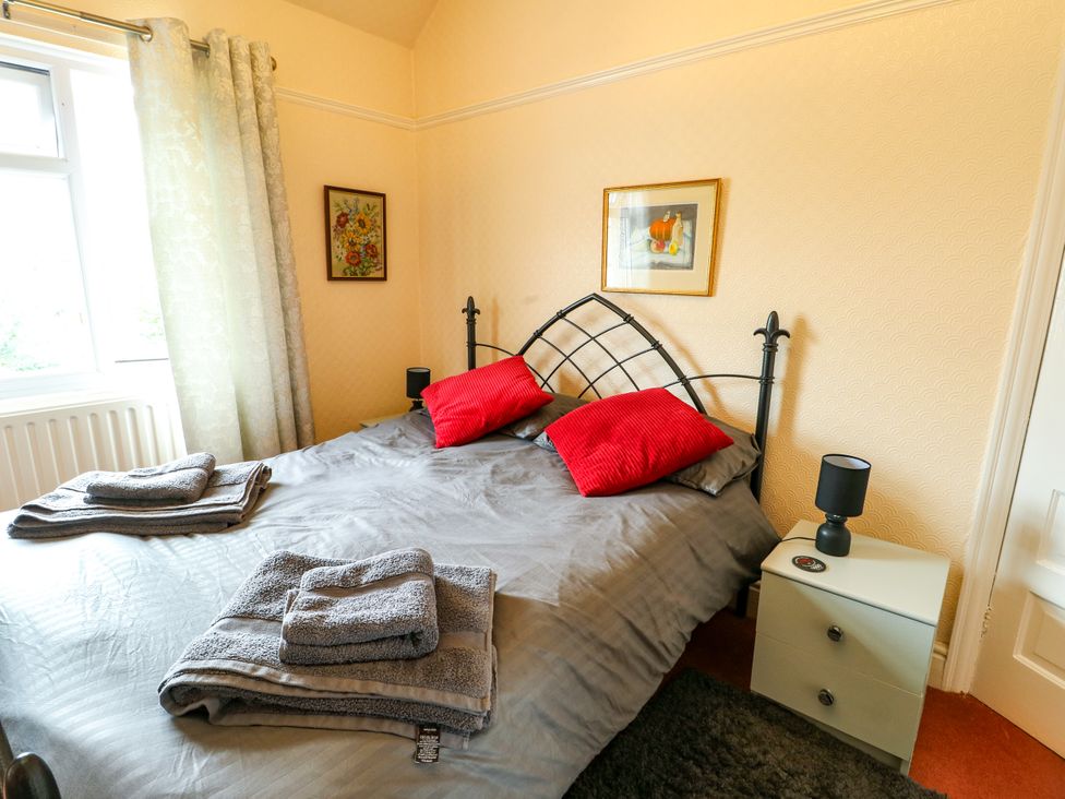 A bedroom with a bed and bedside table at Gwynfa in Old Colwyn
