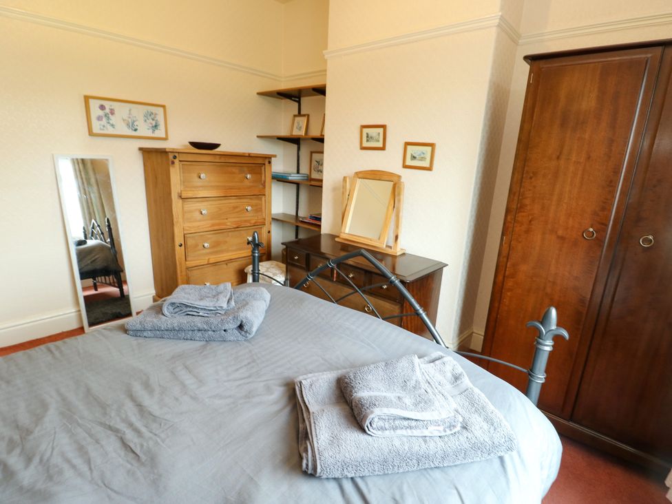 A bedroom with a bed and dresser drawers at Gwynfa in Old Colwyn
