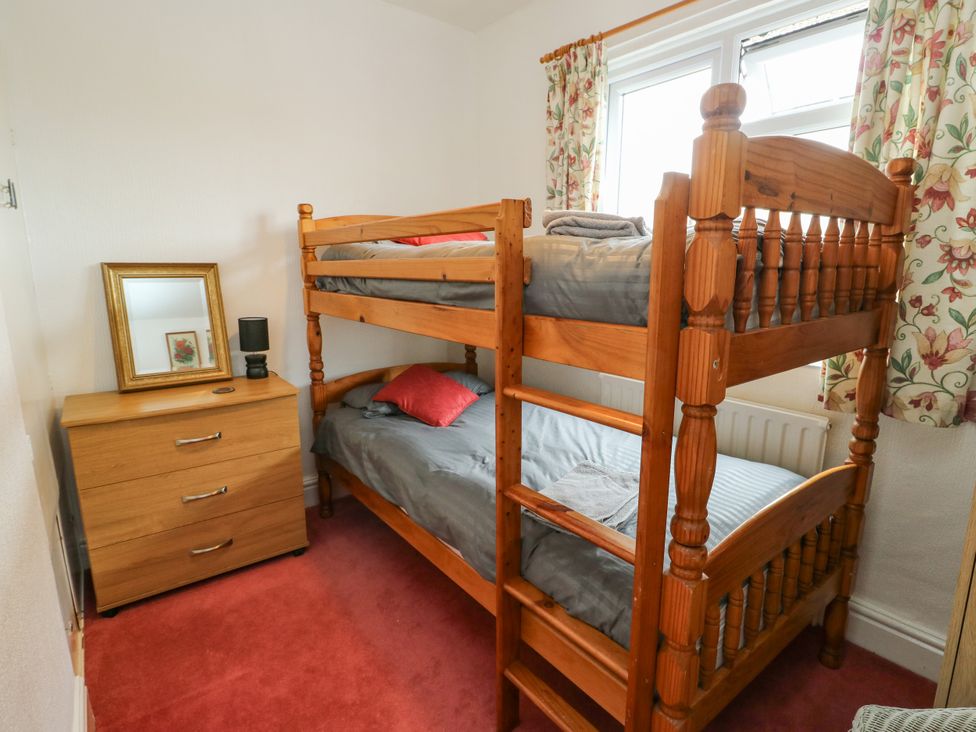 A bedroom with a bunk bed and dresser at Gwynfa in Old Colwyn