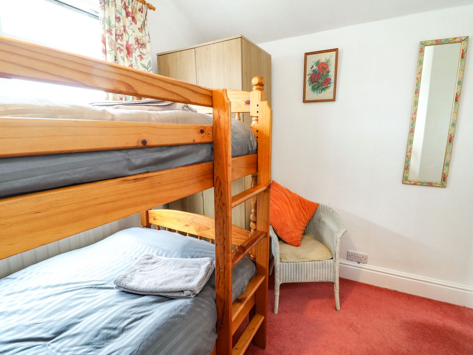 A bedroom with a bunk bed and a single bed at Gwynfa in Old Colwyn