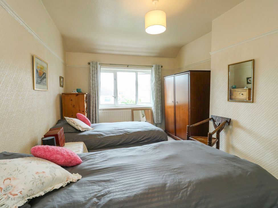 A bedroom with two single beds and a wardrobe at Gwynfa in Old Colwyn