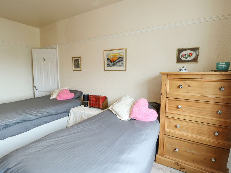 A bedroom with two beds and a dresser at Gwynfa in Old Colwyn