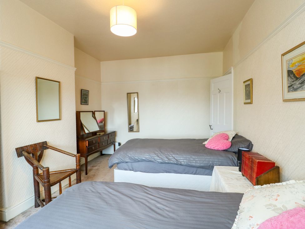 A bedroom with two beds and a dressing table at Gwynfa Old Colwyn