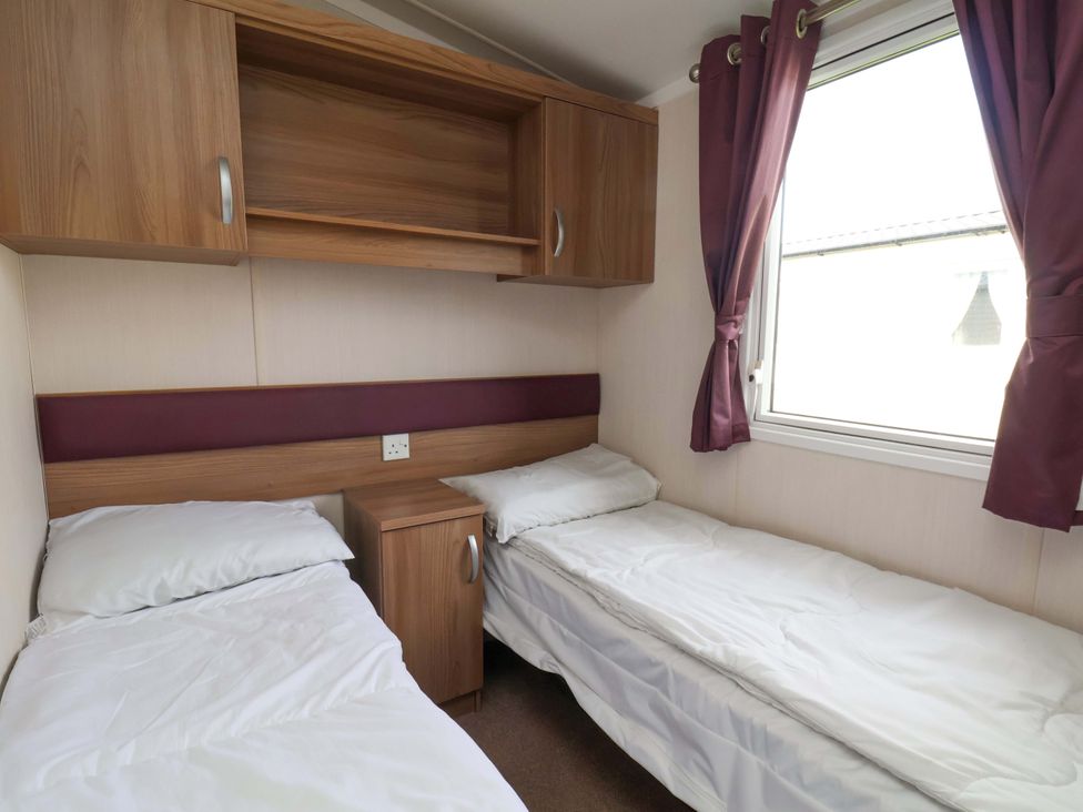 A bedroom with two beds and a shelf at Caravan B14 Beechrise Filey