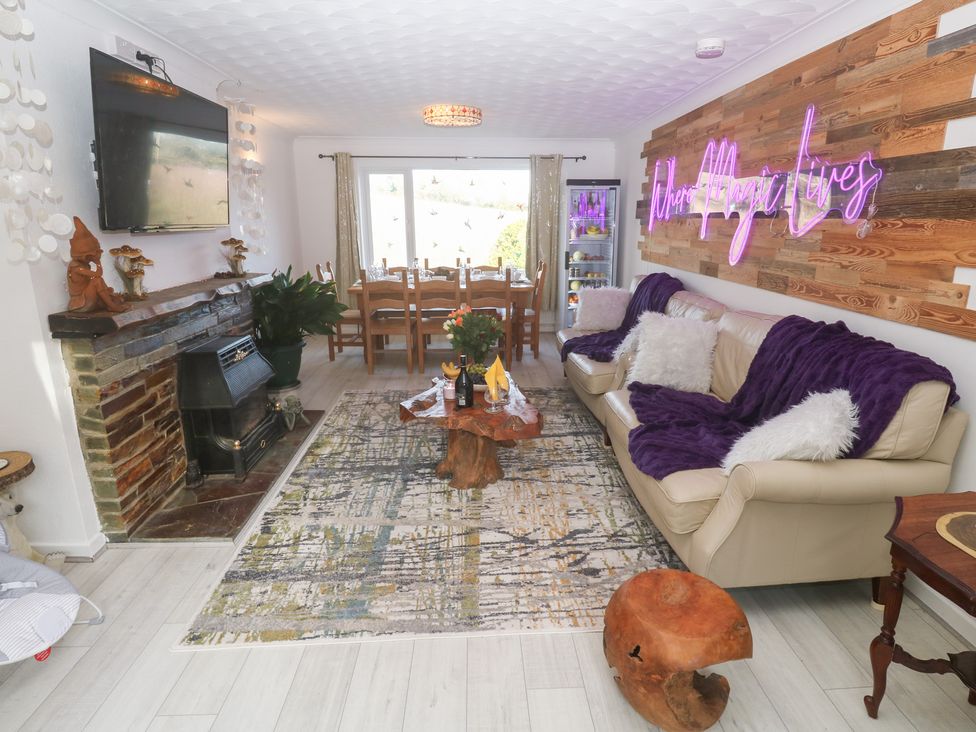 A living room with a sofa and fireplace at Piskies Magic Home