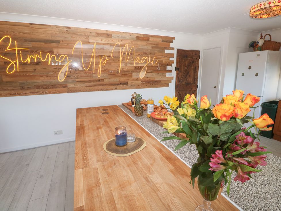 A kitchen with a wooden counter and decorative lighting at Piskies Magic Home 