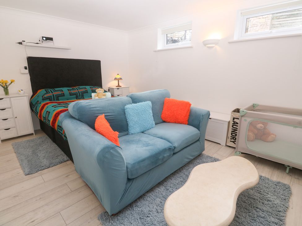 A bedroom with a bed and sofa at Piskies Magic Home