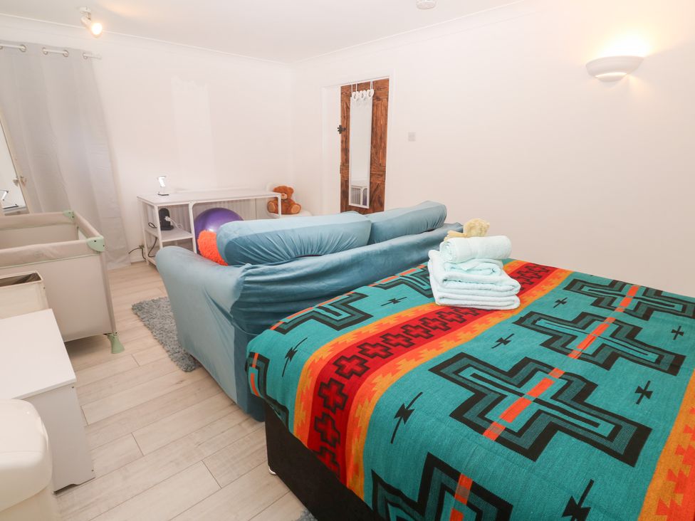 A bedroom with a bed and sofa at Piskies Magic Home