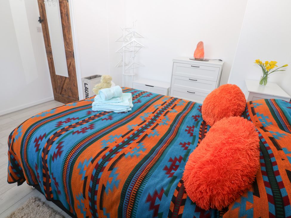 A bedroom with a bed and towels at Piskies Magic Home