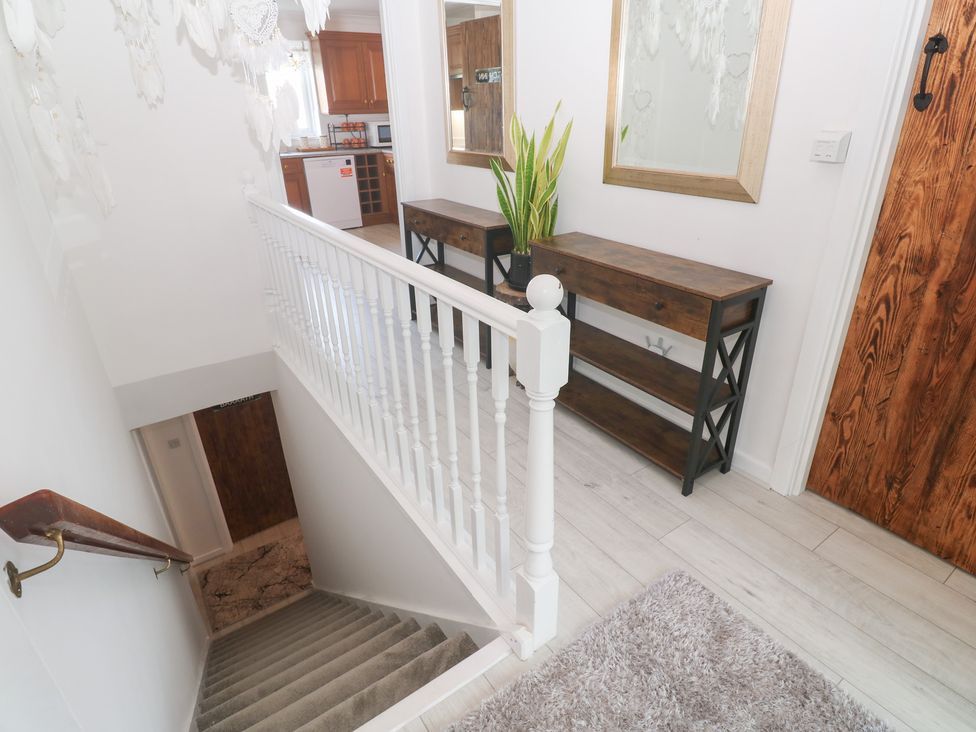 A hallway with a staircase and decorative furniture at Piskies Magic Home