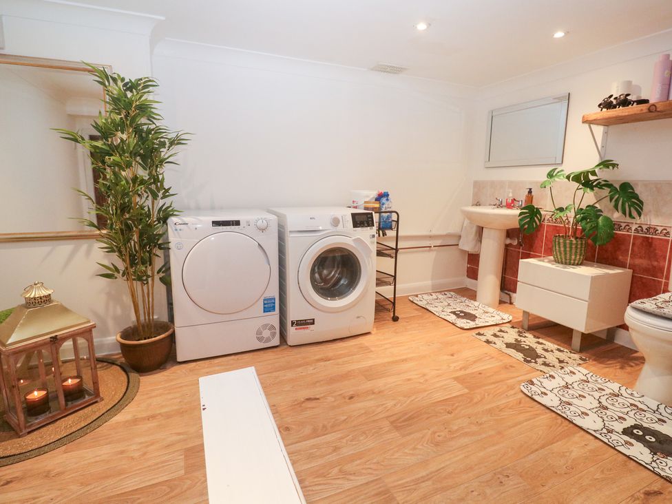 A laundry room with washing machines and plants at Piskies Magic Home