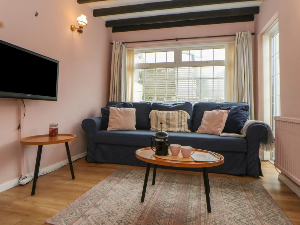 A living room with a sofa and coffee table at 1 Alpha Cottages in Tenby